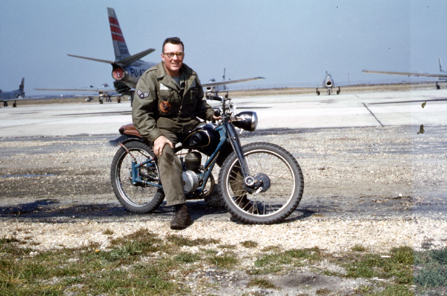 France- Bob sitting on motor cycle in front of F86s